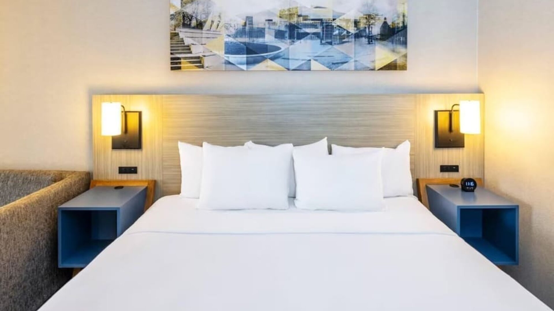 Contemporary guest room featuring a king-size bed, modern lighting and artwork above the headboard at Comfort Inn Truro.
