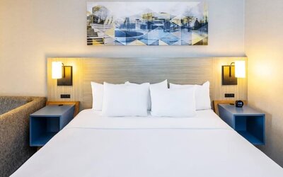 Contemporary guest room featuring a king-size bed, modern lighting and artwork above the headboard at Comfort Inn Truro.