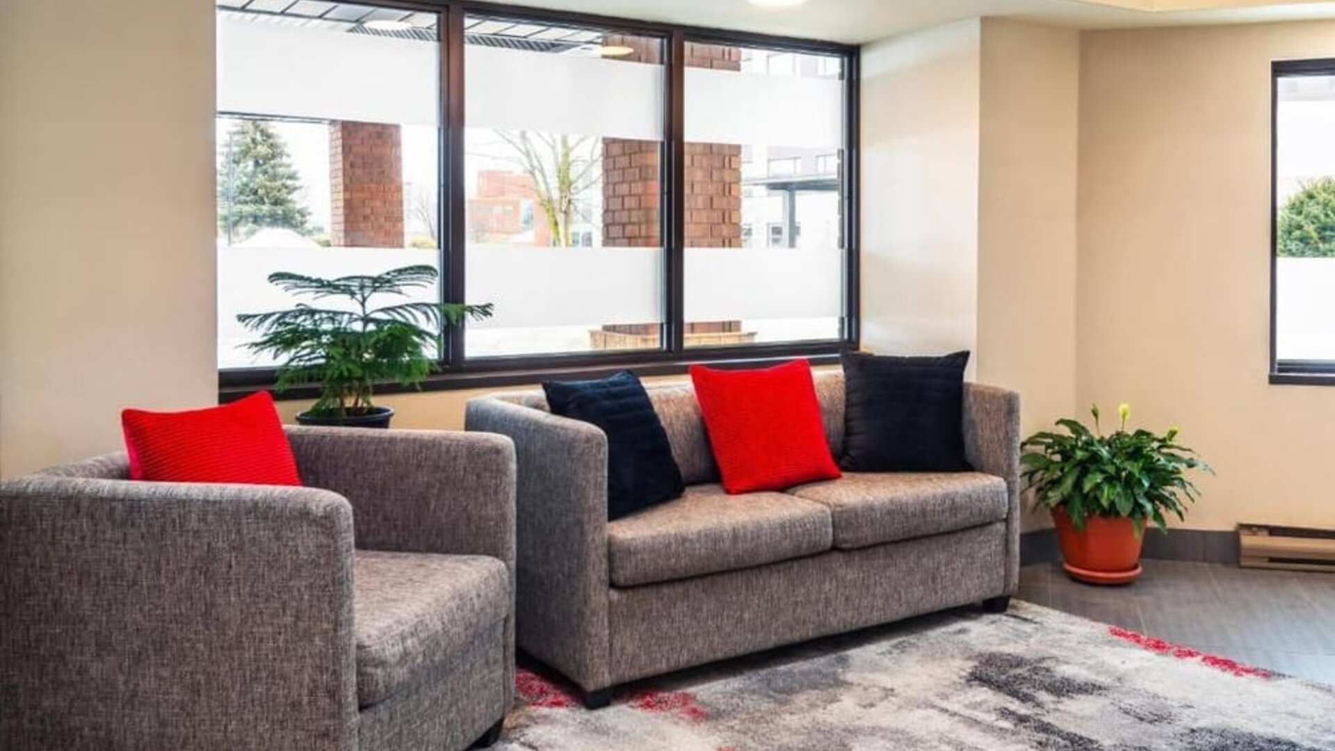 Inviting hotel lobby featuring comfortable seating, large windows and modern décor accented with vibrant cushions at Comfort Inn Truro.
