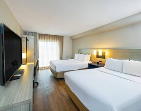 Spacious guest room featuring two beds, a large television and a contemporary design suitable for families or groups at Comfort Inn Truro.