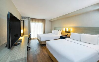 Spacious guest room featuring two beds, a large television and a contemporary design suitable for families or groups at Comfort Inn Truro.