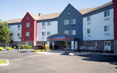 Modern bathroom featuring a spacious vanity, illuminated mirror and a glass-enclosed shower at Candlewood Suites Boise.