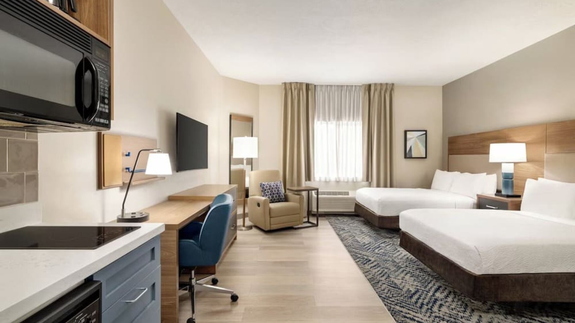 Studio-style guest room featuring two beds, a kitchenette, a dedicated workspace and modern amenities at Candlewood Suites Boise.