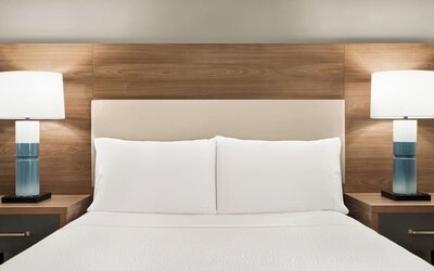 Guest room featuring a plush king-size bed, contemporary furnishings and bedside lighting for a comfortable stay at Candlewood Suites Boise.