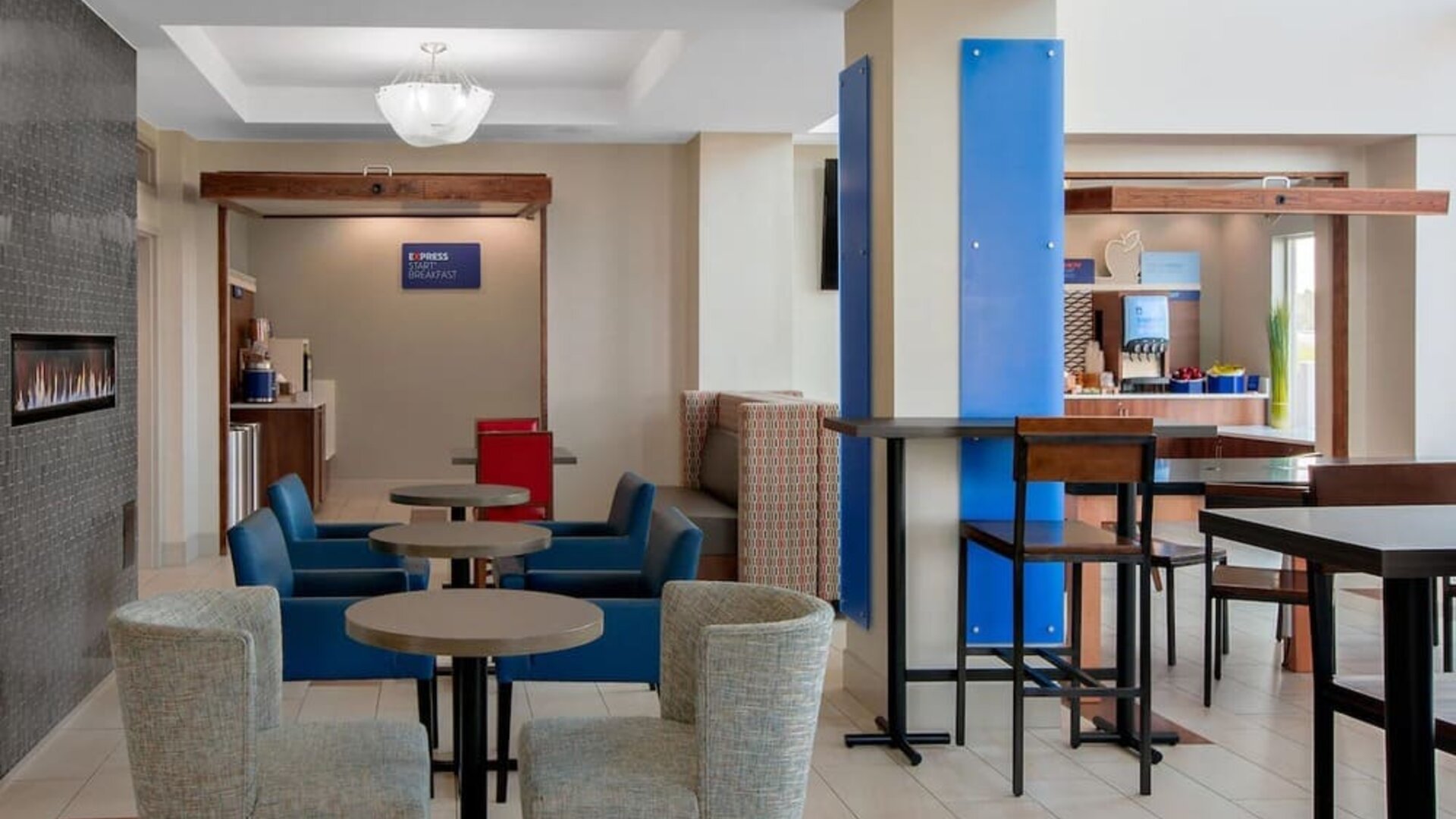 Dining area featuring contemporary seating, a fireplace and a complimentary Express Start Breakfast station at Holiday Inn Express & Suites Ontario.