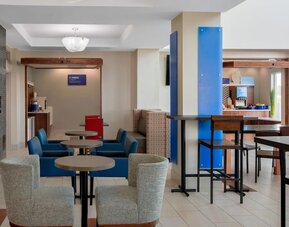 Dining area featuring contemporary seating, a fireplace and a complimentary Express Start Breakfast station at Holiday Inn Express & Suites Ontario.