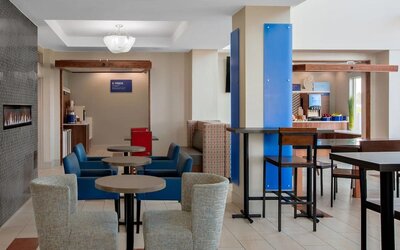 Dining area featuring contemporary seating, a fireplace and a complimentary Express Start Breakfast station at Holiday Inn Express & Suites Ontario.