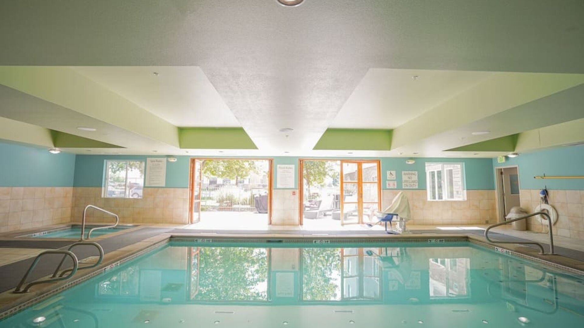 Indoor swimming pool featuring accessible entry points, natural light and a relaxing environment for guests at Holiday Inn Express & Suites Ontario.
