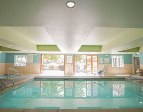 Indoor swimming pool featuring accessible entry points, natural light and a relaxing environment for guests at Holiday Inn Express & Suites Ontario.