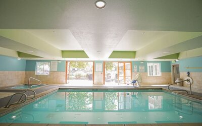 Indoor swimming pool featuring accessible entry points, natural light and a relaxing environment for guests at Holiday Inn Express & Suites Ontario.