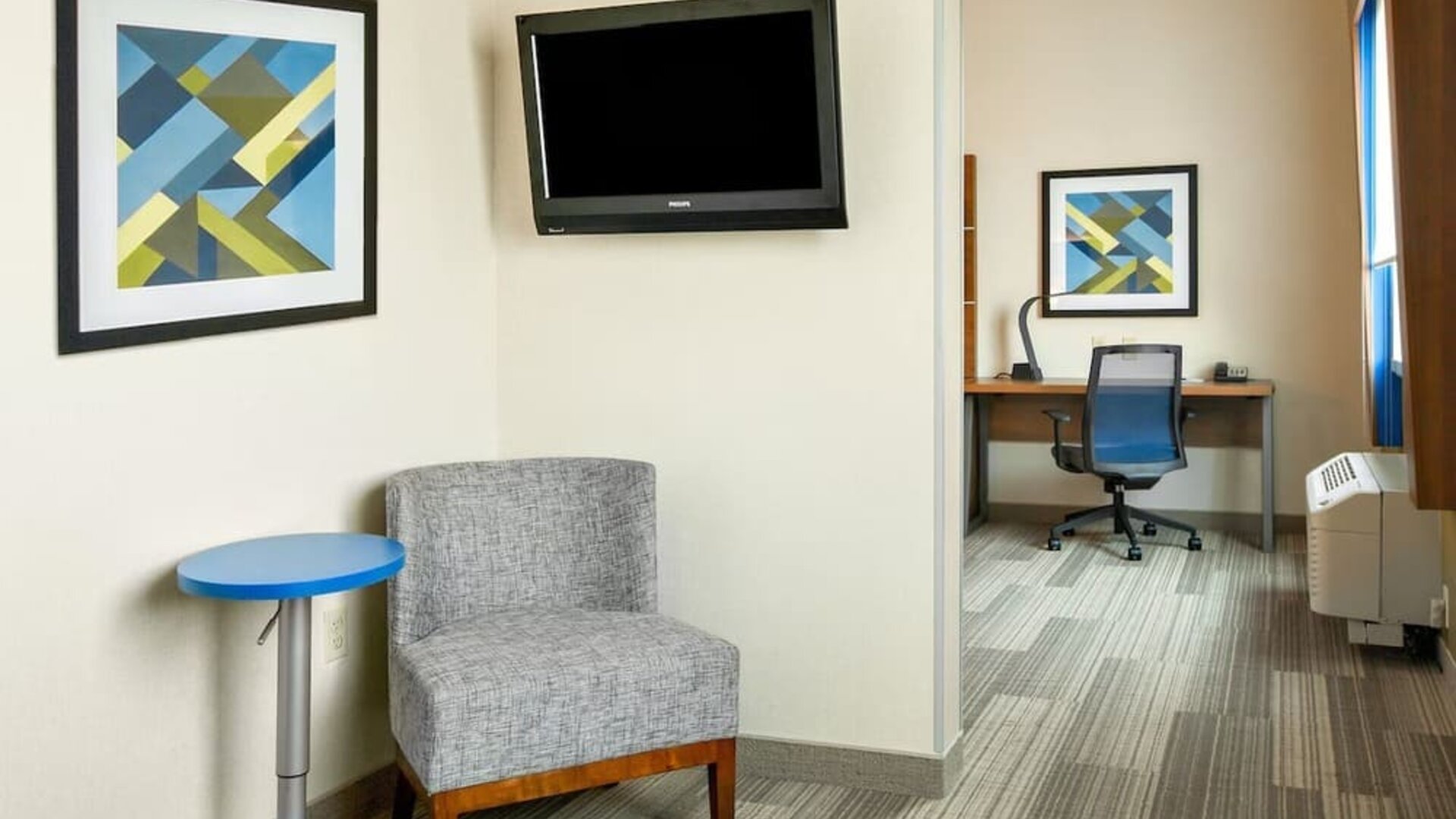 In-room workspace featuring a dedicated desk, comfortable seating and a separate work area within the guest suite at Holiday Inn Express & Suites Ontario.