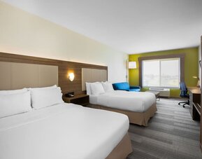 Guest room featuring two beds, a comfortable sofa, a dedicated workspace and modern amenities at Holiday Inn Express & Suites Ontario.