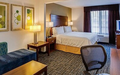Spacious guest room featuring a king-size bed, a comfortable seating area, a work desk and contemporary furnishings at Holiday Inn Express SFO Airport North.