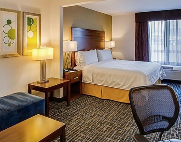 Spacious guest room featuring a king-size bed, a comfortable seating area, a work desk and contemporary furnishings at Holiday Inn Express SFO Airport North.