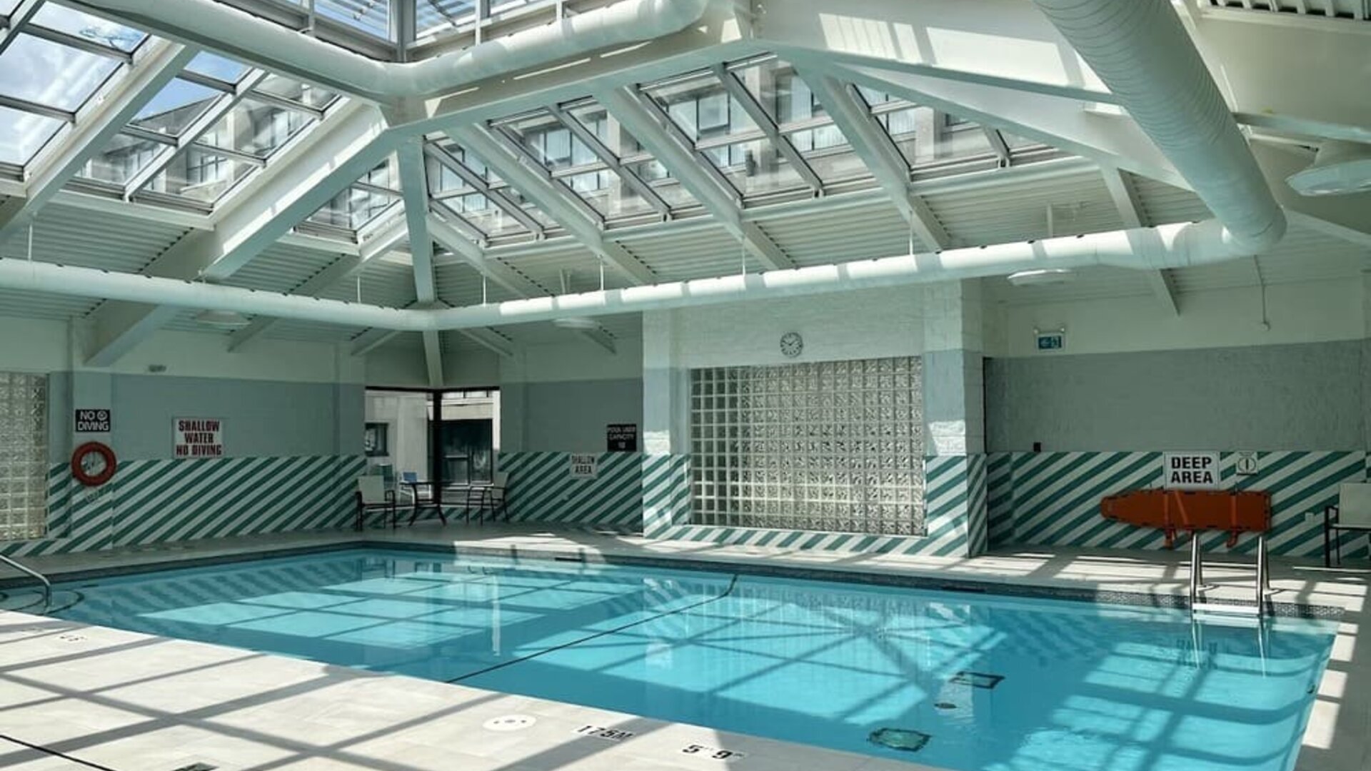 Indoor swimming pool featuring a glass atrium ceiling, abundant natural light and a relaxing atmosphere at Holiday Inn Toronto Airport East.