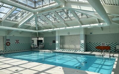 Indoor swimming pool featuring a glass atrium ceiling, abundant natural light and a relaxing atmosphere at Holiday Inn Toronto Airport East.