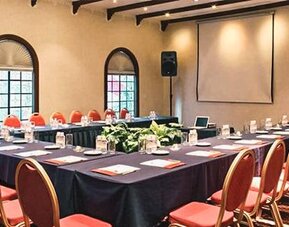 Meeting room arranged in a U-shaped conference layout with presentation equipment and banquet seating at Hotel Geneve.