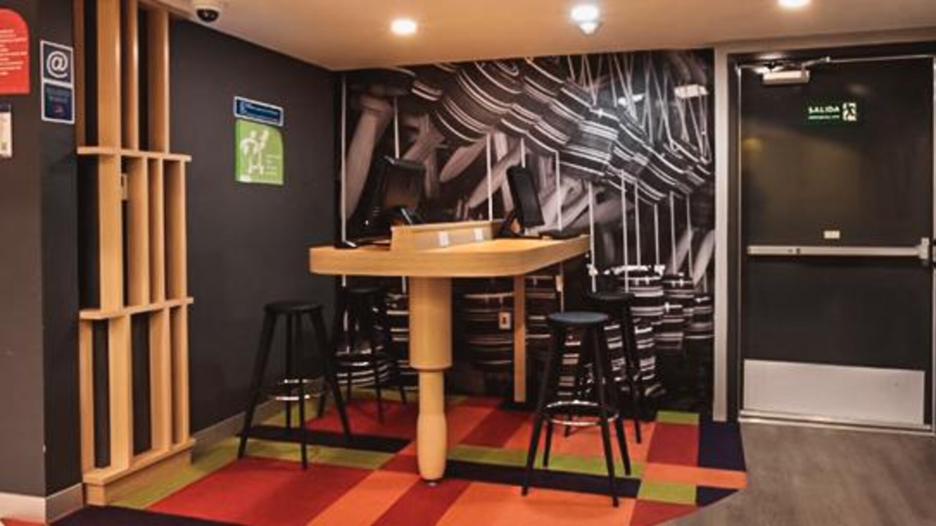 Casual dining area with communal tables, contemporary seating, geometric décor, and an open layout at Ibis Styles Mexico Reforma.