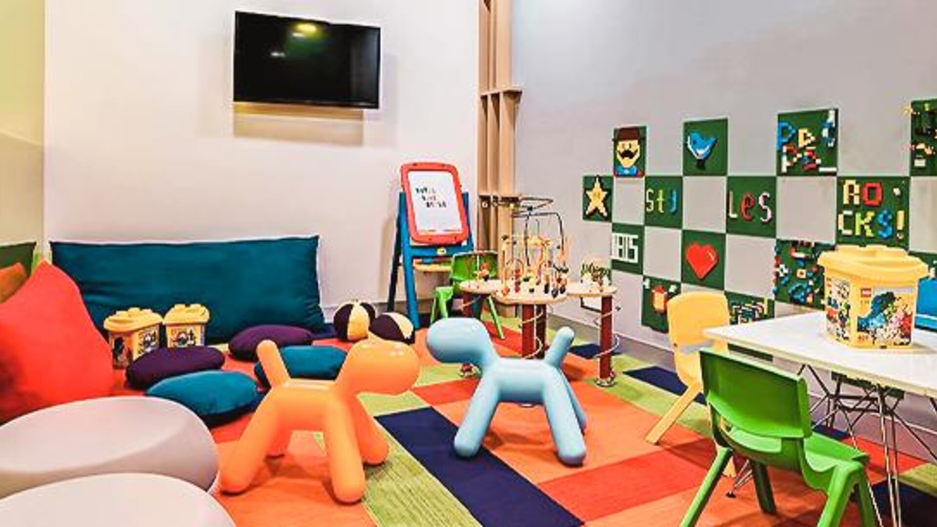 Children's play area featuring toys, activity tables, colorful seating, and entertainment options at Ibis Styles Mexico Reforma.