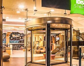 Glass entrance with revolving doors, contemporary lighting, and a welcoming reception area at Ibis Styles Mexico Reforma.