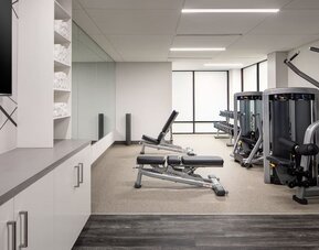 Fitness center featuring strength-training equipment, free weights, and a bright, modern workout space at Houston Marriott South at Hobby Airport.