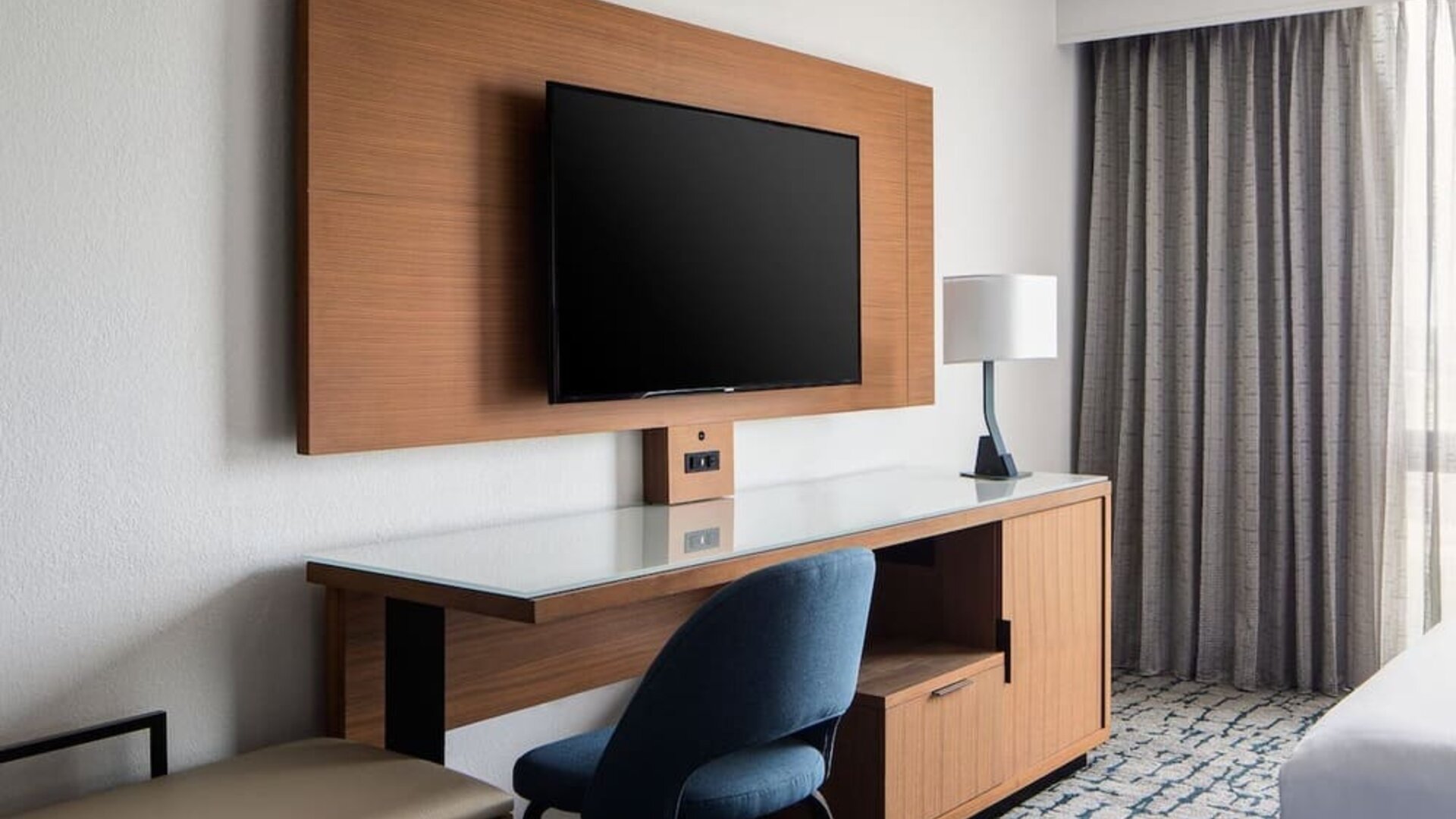 In-room workspace featuring a spacious desk, mounted television, and ergonomic seating at Houston Marriott South at Hobby Airport.