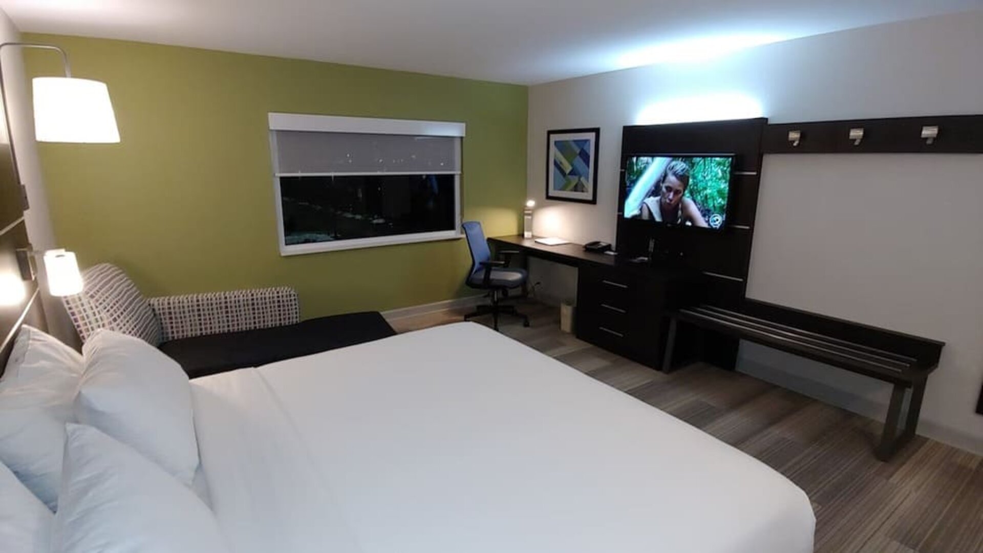 Guest room featuring a king bed, a comfortable seating area, a dedicated workspace, and modern amenities at Holiday Inn Express Rolling Meadows-Schaumburg.