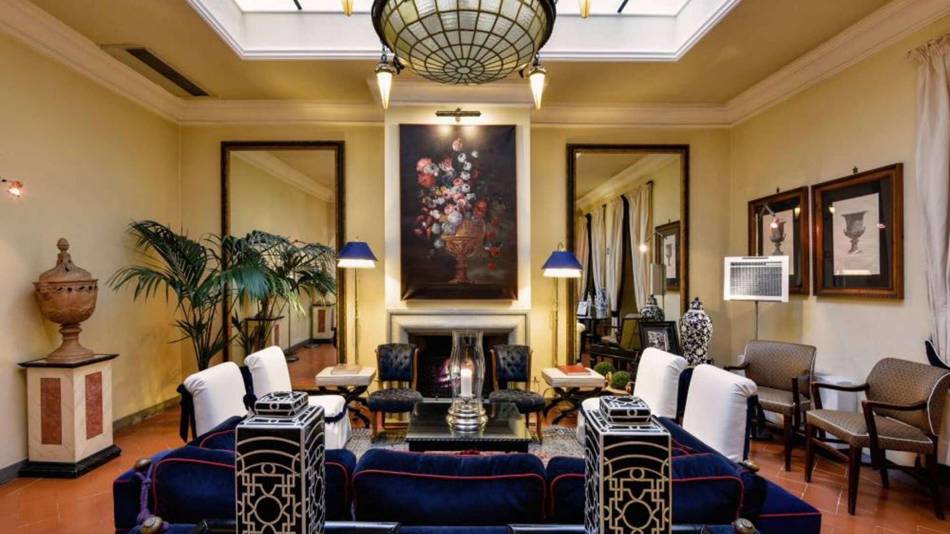 Lobby lounge featuring a decorative fireplace, classic furnishings, artwork, and sophisticated Italian-inspired décor at Cellai Boutique Hotel.