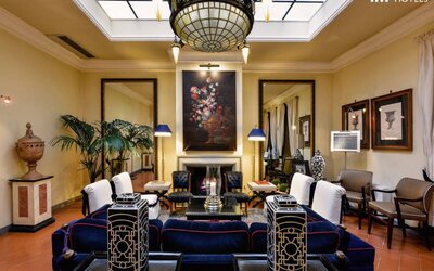 Lobby lounge featuring a decorative fireplace, classic furnishings, artwork, and sophisticated Italian-inspired décor at Cellai Boutique Hotel.