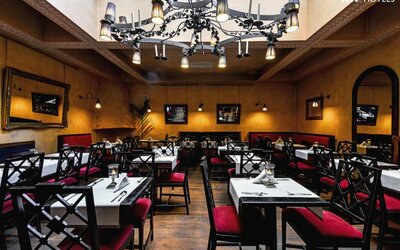 Restaurant featuring elegant chandeliers, upholstered seating, intimate dining tables, and warm ambient lighting at Cellai Boutique Hotel.