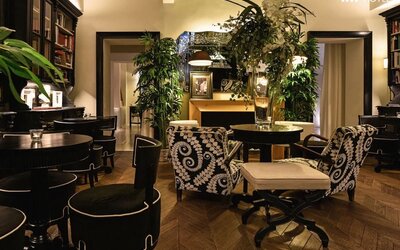 Lobby area featuring decorative floral arrangements, library-style shelving, patterned seating, and an intimate atmosphere at Cellai Boutique Hotel.