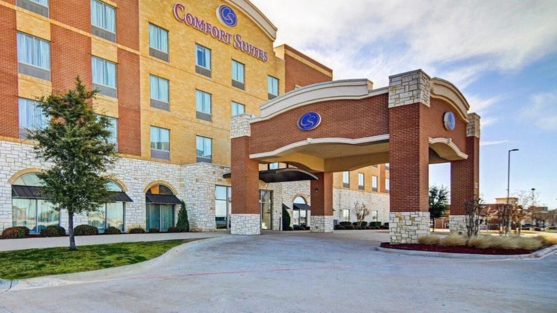 Exterior view of the hotel entrance with a covered porte-cochère and multi-storey façade at Comfort Suites Frisco.