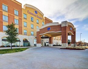 Exterior view of the hotel entrance with a covered porte-cochère and multi-storey façade at Comfort Suites Frisco.