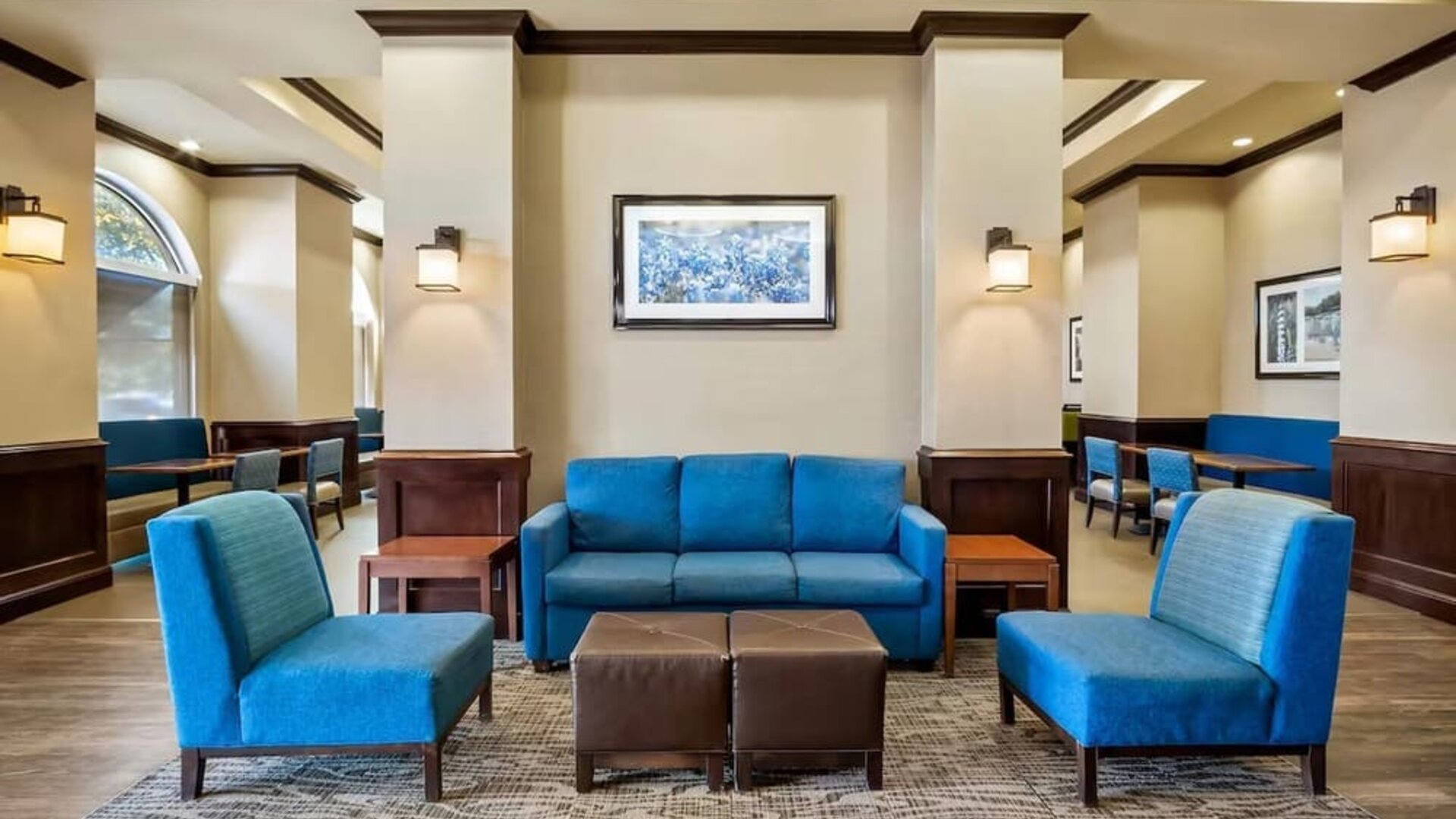 Hotel lobby seating area with blue upholstered furniture, accent lighting, and casual gathering spaces at Comfort Suites Frisco.