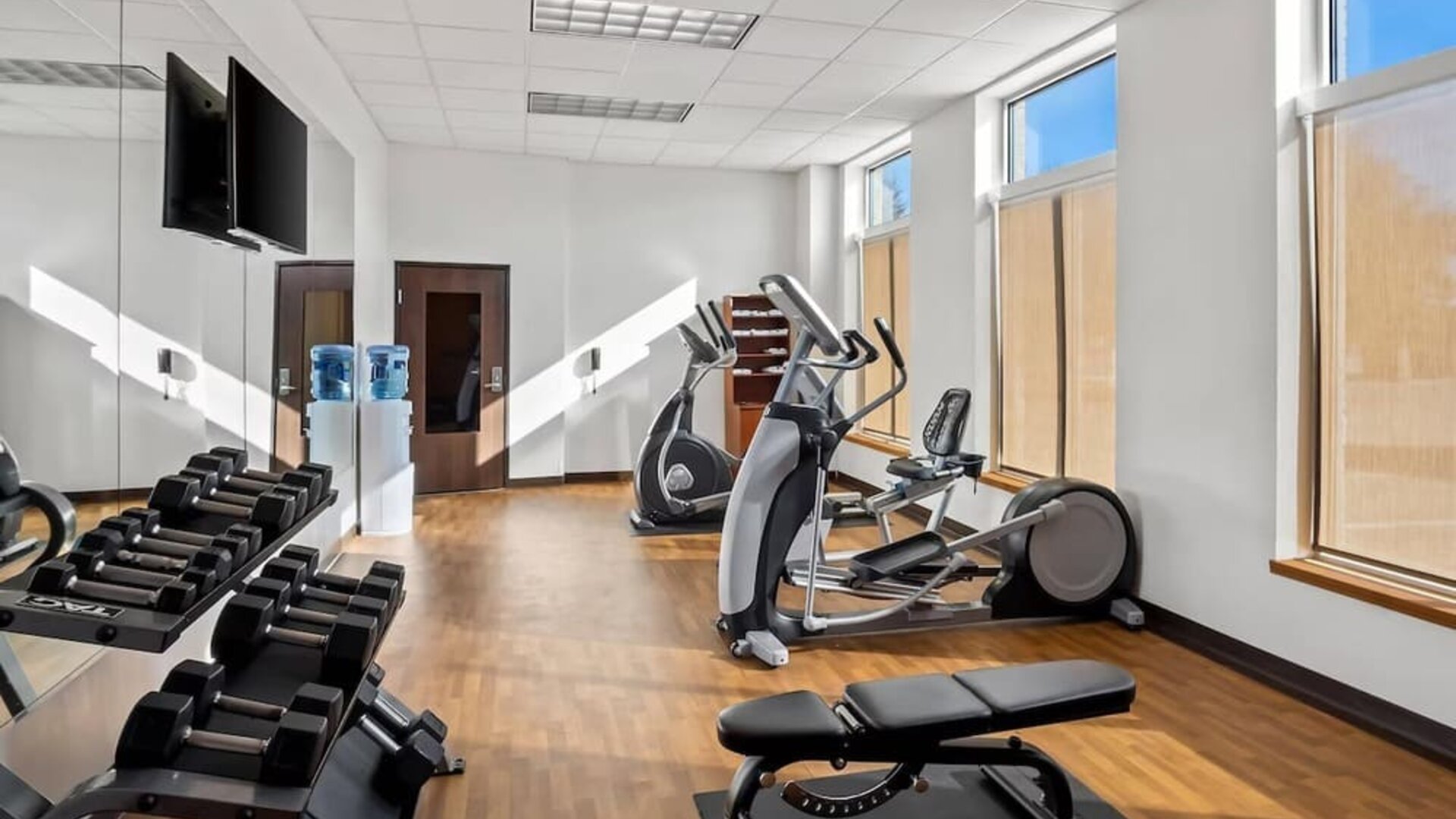 Fitness centre with cardio equipment, free weights, a weight bench, and floor-to-ceiling mirrors at Comfort Suites Frisco.
