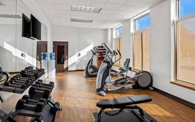 Fitness centre with cardio equipment, free weights, a weight bench, and floor-to-ceiling mirrors at Comfort Suites Frisco.