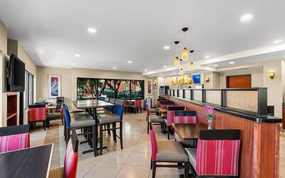 Bright dining and breakfast area with a variety of tables, comfortable seating, and large windows at Comfort Suites Vacaville-Napa Valley Area.