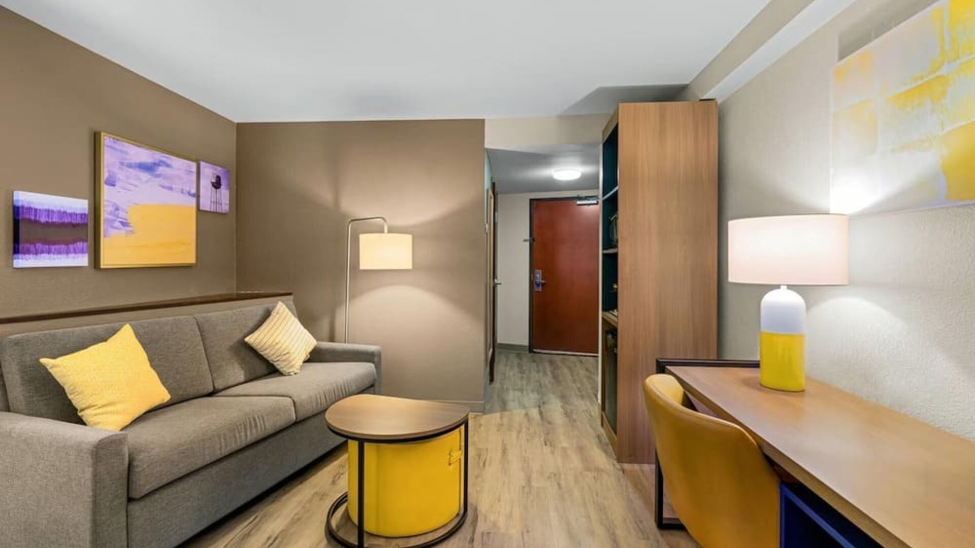 Suite lounge area featuring a sofa, workspace, contemporary furnishings, and warm lighting at Comfort Suites Vacaville-Napa Valley Area.