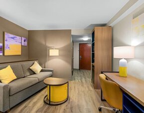 Suite lounge area featuring a sofa, workspace, contemporary furnishings, and warm lighting at Comfort Suites Vacaville-Napa Valley Area.