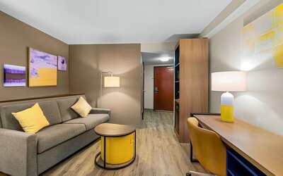 Suite lounge area featuring a sofa, workspace, contemporary furnishings, and warm lighting at Comfort Suites Vacaville-Napa Valley Area.