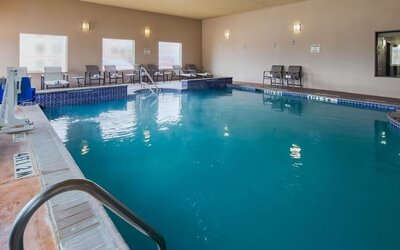 Indoor swimming pool featuring lounge seating and an accessible pool lift at Best Western Granbury Inn & Suites.