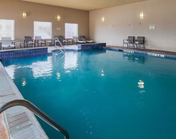 Indoor swimming pool featuring lounge seating and an accessible pool lift at Best Western Granbury Inn & Suites.