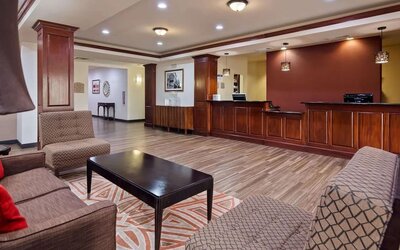 Welcoming reception and lobby area featuring comfortable seating, wood-panelled front desk, and contemporary flooring at Best Western Granbury Inn & Suites.
