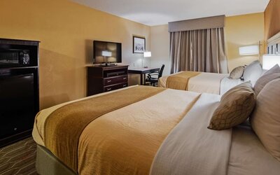 Guest room featuring two beds, flat-screen television, workspace, microwave, and mini refrigerator at Best Western Granbury Inn & Suites.
