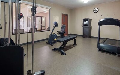 Fitness centre equipped with a treadmill, exercise bike, weight bench, and strength-training equipment at Best Western Granbury Inn & Suites.