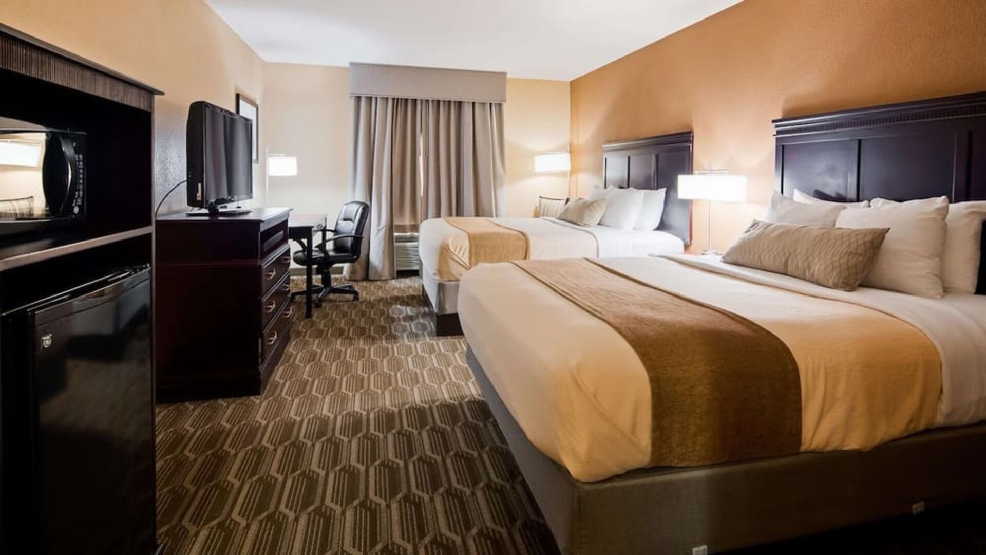 Guest room featuring two beds, flat-screen television, workspace, microwave, and mini refrigerator at Best Western Granbury Inn & Suites.