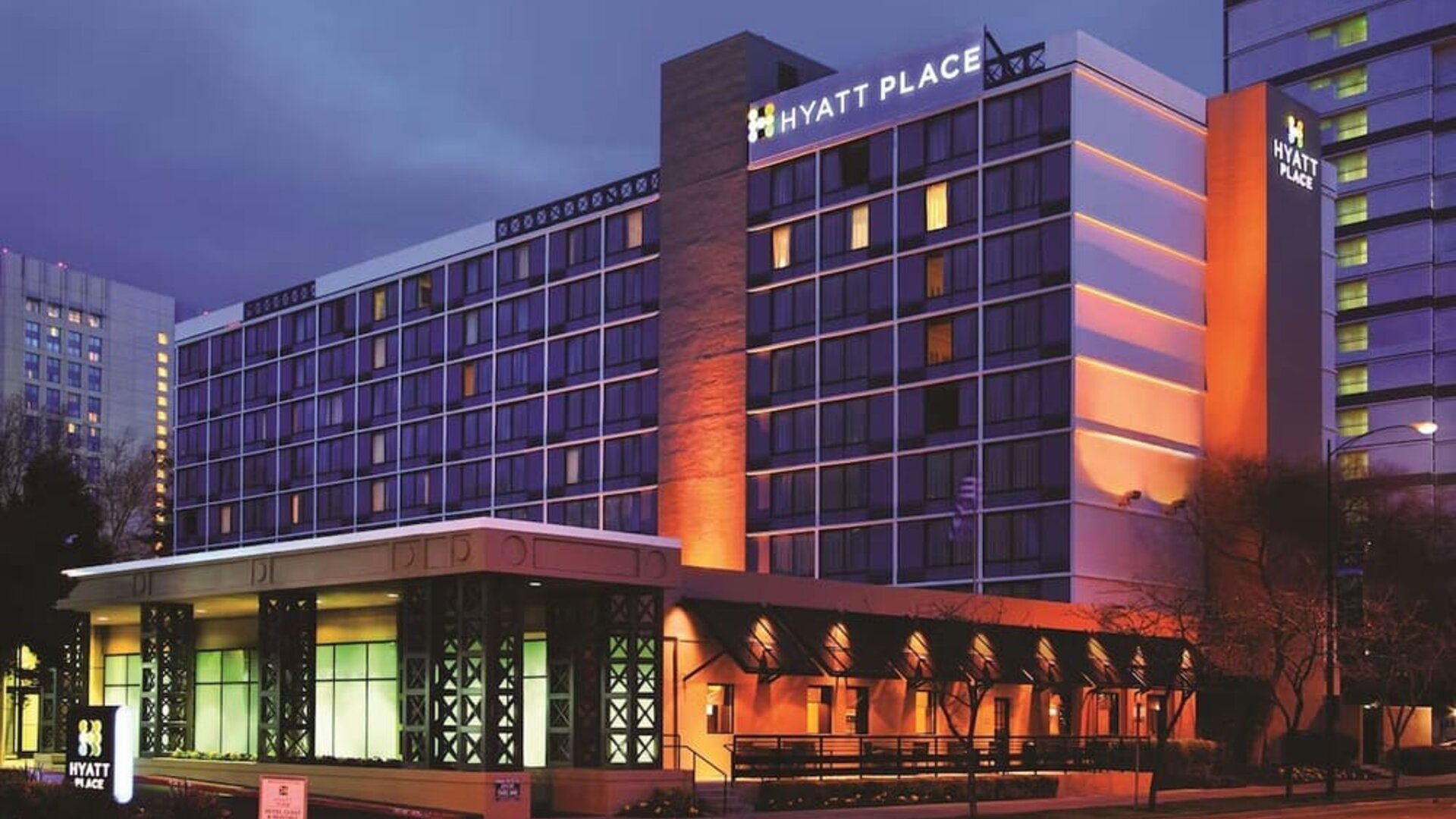 Exterior view of the multi-storey hotel illuminated in the evening at Hyatt Place San Jose Downtown.