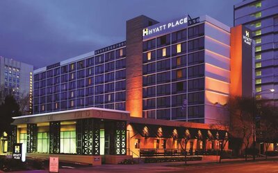 Exterior view of the multi-storey hotel illuminated in the evening at Hyatt Place San Jose Downtown.