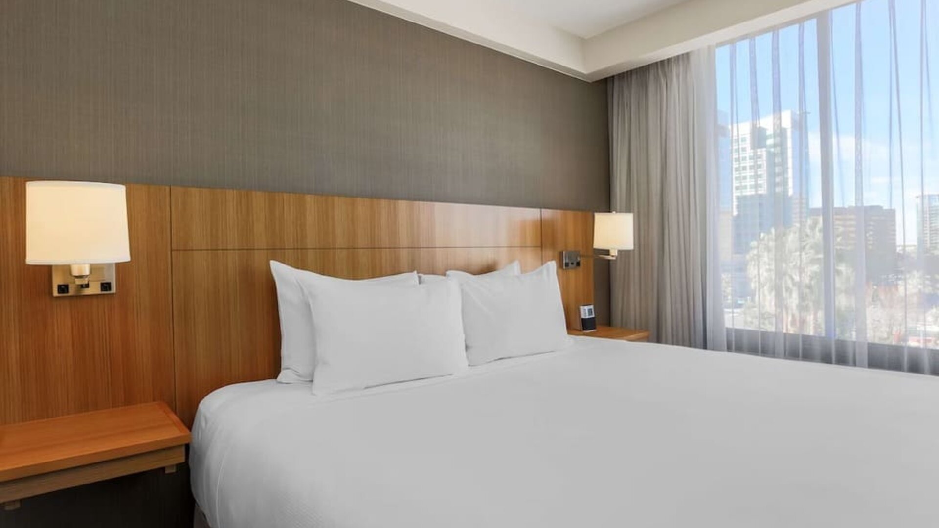 Bright king guest room featuring a king bed, bedside lighting, and a large window providing natural light at Hyatt Place San Jose Downtown.