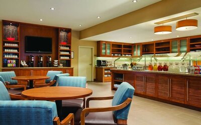 Bright dining area featuring comfortable seating, beverage stations, and a breakfast buffet counter at Hyatt Place San Jose Downtown.